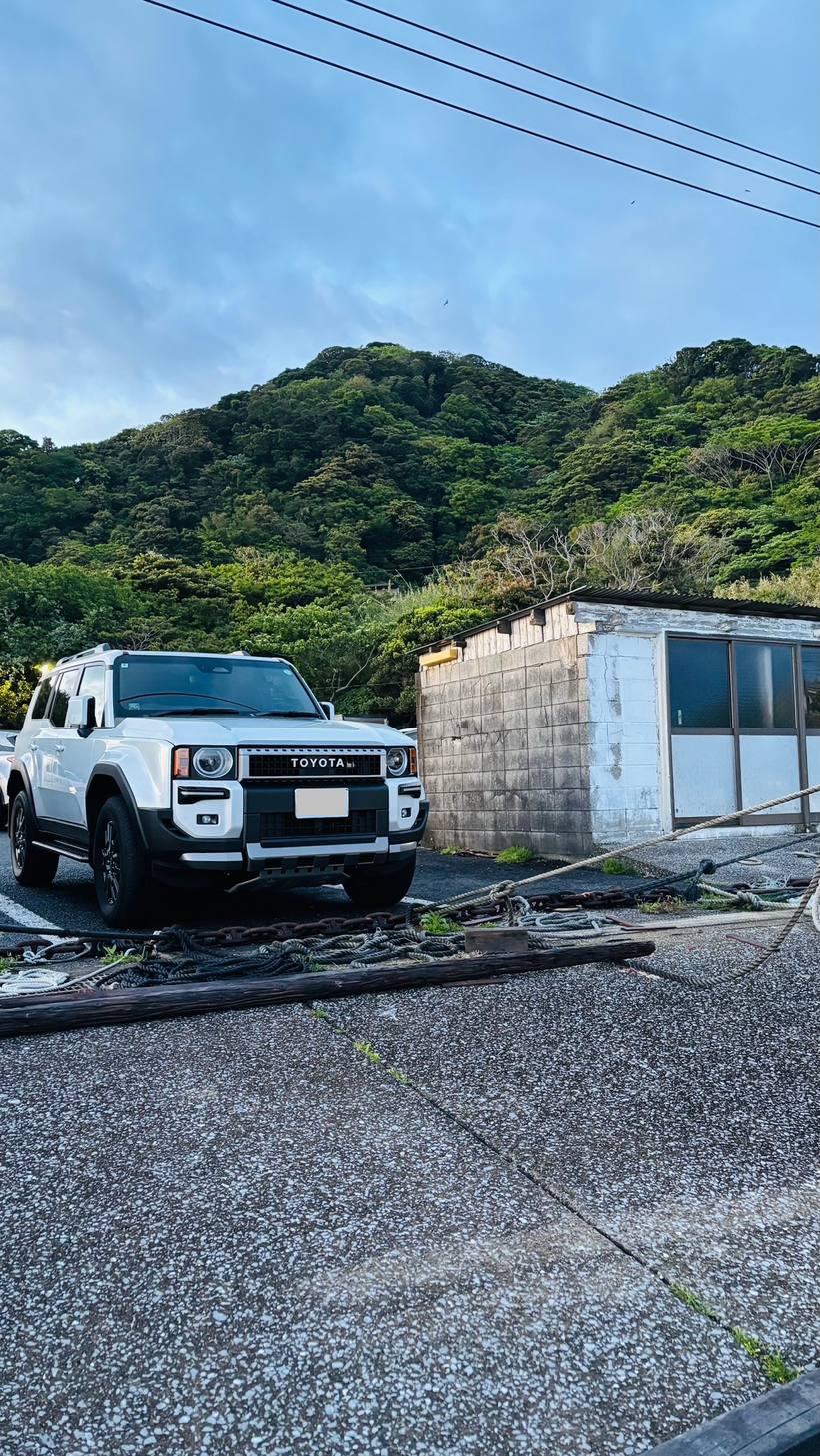山を背にした漁港の駐車場に停めたランドクルーザー250
