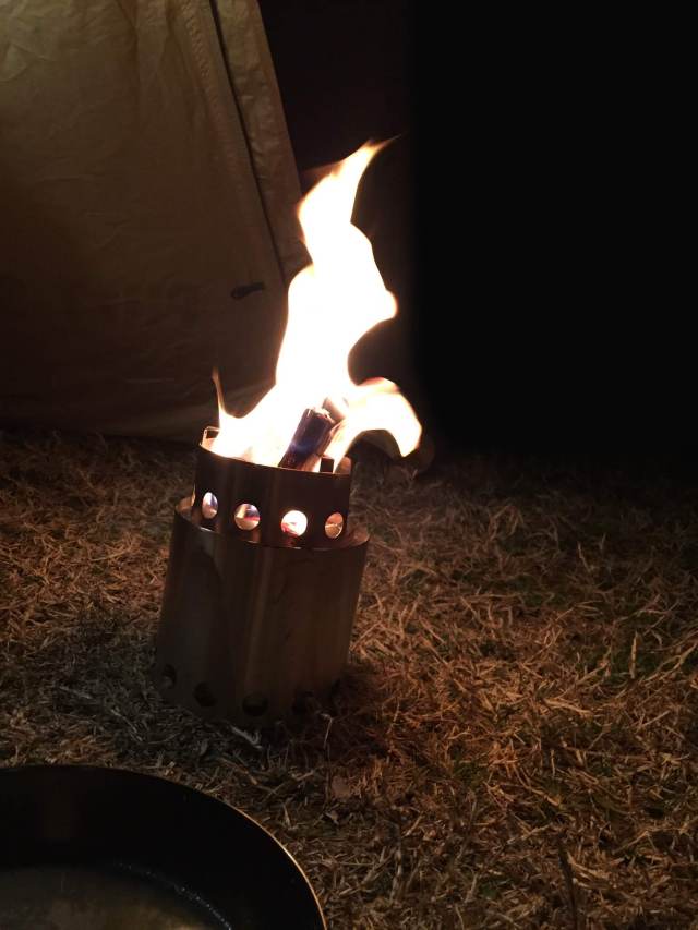 夜の草地で燃える小さな焚き火台
