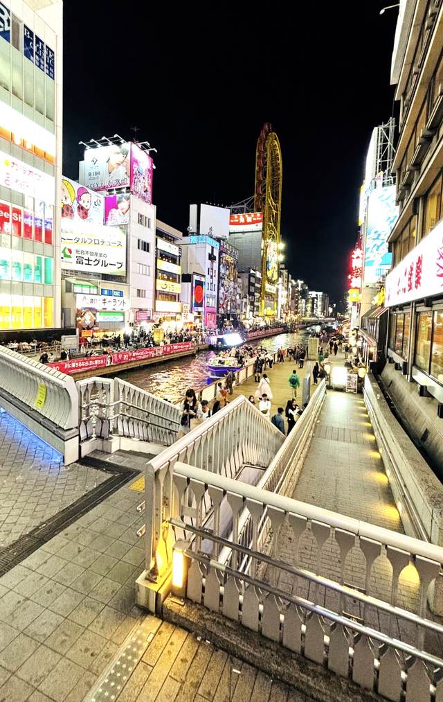 夜のネオンが輝く川沿いの繁華街と観覧車