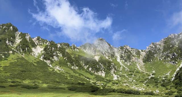 長野・木曽駒ヶ岳。青空の下、岩山と緑の斜面が広がる景色